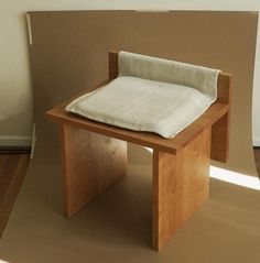 a small wooden bench with a cushion on it