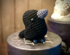 a crocheted black bird sitting on top of a table