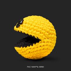 a yellow and black knitted object with sunglasses on it's head, in the shape of a snake