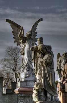 an old cemetery with angel statues and tombstones