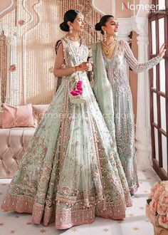 two women in wedding dresses standing next to each other