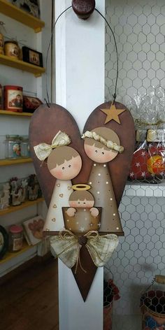 two wooden angels hanging from the side of a wall