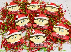 christmas cookies decorated with the names of children's name and santa hats on them