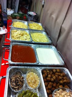 several trays of food are lined up on a table