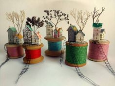 several spools of thread with houses and trees in them on a white surface