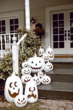 pumpkins with faces carved into them sitting on the steps in front of a house