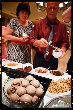 two people are serving themselves food at a buffet