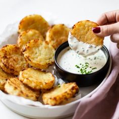 a person dipping some food into a bowl