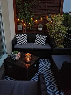 an outdoor living area with couches, table and potted plants on the balcony