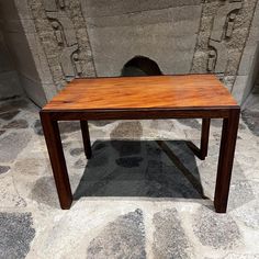 a wooden table sitting on top of a stone floor