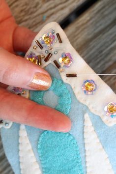 someone is sewing something on a piece of fabric with pins and needles attached to it