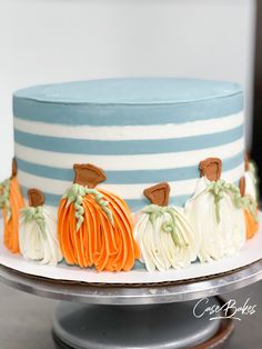 there is a blue and white cake with pumpkins on the top, along with other decorations