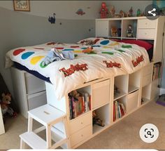 a child's bed with bookshelves and toys