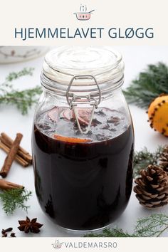 a glass jar filled with liquid next to pine cones and cinnamons