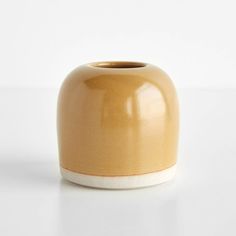 a yellow vase sitting on top of a white table