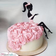 a cake decorated with pink flowers and a silhouette of a woman