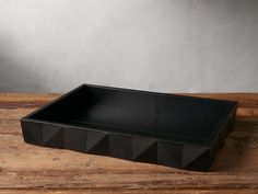 an empty black tray on a wooden table