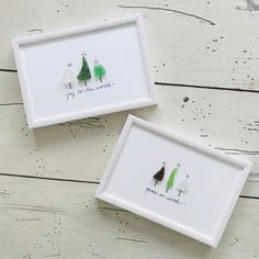 two framed pictures with trees on them sitting next to each other