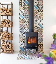 a wood burning stove in a living room with colorful tiles on the wall and floor