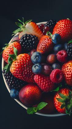 a white bowl filled with lots of different types of berries on top of each other