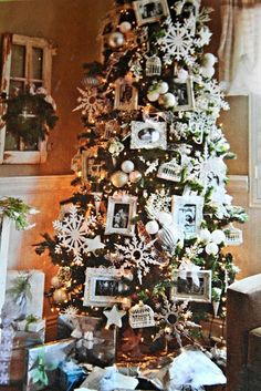 a christmas tree decorated with white and silver ornaments, snowflakes and other holiday decorations