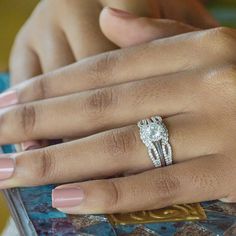 a woman's hand with two engagement rings on her left and the middle finger