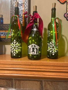 three green wine bottles with christmas decorations on them