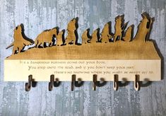 a wooden sign with dogs on it and hooks hanging from the wall next to each other