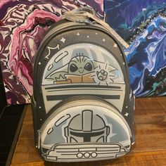 two backpacks with star wars designs on them are sitting on a table next to each other