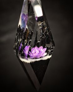 a black diamond with purple flowers on it's side and an upside down view of the inside