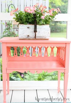 a pink bench sitting on top of a wooden floor next to a potted plant