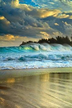 an ocean beach with waves crashing on the shore and clouds in the sky above it