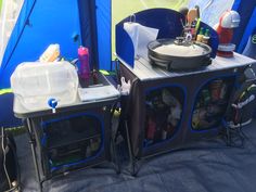 there are two coolers sitting next to each other in the camping tent with food inside