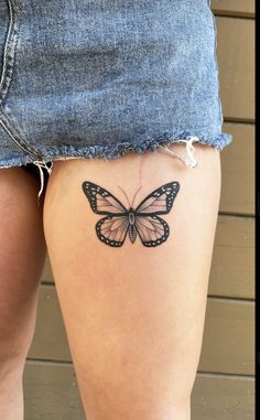 a woman's thigh with a small butterfly tattoo on the back of her leg