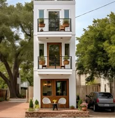 a white two story house with balconies on the second floor