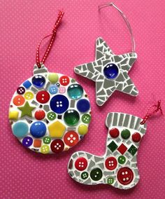 two christmas ornaments made out of buttons on a pink tablecloth with polka dot dots