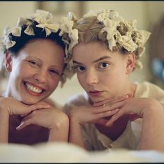 two young women with flower crowns on their heads are posing for the camera in front of a mirror