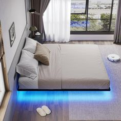 a bed that has some lights on it in the middle of a room next to a window