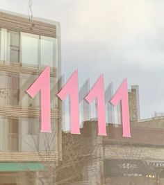 a building with pink numbers on the front and side of it's glass windows