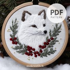 a white fox with red berries on it's head is shown in the snow