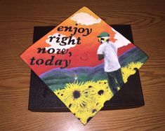 a graduation cap with the words enjoy right now today on it and sunflowers