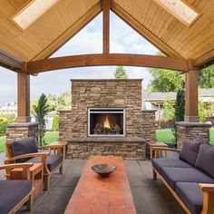 an outdoor living area with couches and a fireplace