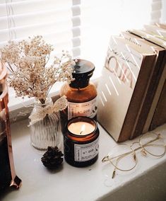 a candle and some books on a window sill