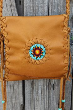 "This beaded leather phone case is made of soft, durable saddle tan leather. This sweet little handbag is great for your smartphone, medicines or just a few things you need to carry. This bag measures 6\" tall, 5 1/2\" wide, has a 48\" adjustable shoulder strap to wear crossbody and a beaded sunflower rosette. We can make this bag in a variety of colors in soft tanned cowhide leather ( see the last photo ). Just leave a note at check out or contact us... This item is MADE TO ORDER. You will not Brown Beaded Shoulder Bag For Everyday Use, Beaded Sunflower, Handmade Leather Purse, Small Leather Bag, Leather Handbags Crossbody, Black Leather Purse, Leather Phone Case, Bead Leather, Black Purses