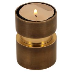 a gold candle holder with a lit candle in it