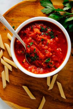 a bowl of pasta sauce with parsley on the side