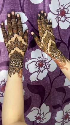 two hands with henna tattoos on them