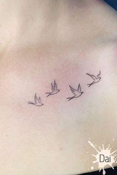 a woman's chest with three small birds flying in the sky above her shoulder