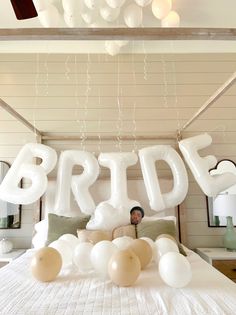 a bed with balloons that spell out the word bride on it and an image of a woman sitting at the end of the bed