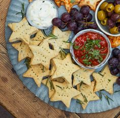 a platter filled with crackers, olives, cheese and other food items